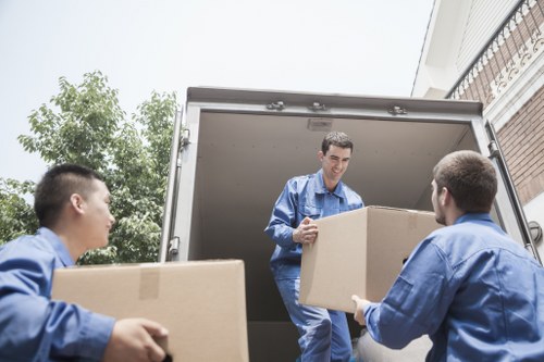 Removal team moving boxes and furniture in a Maida Vale residential street
